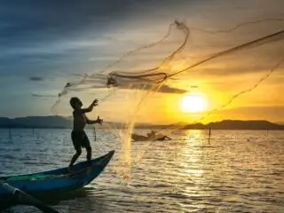Lake in sunrise with fisherman.