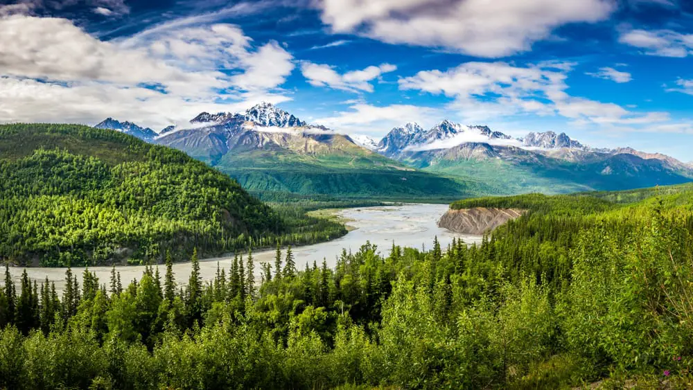 This is an aerial view of the Chugach National Forest with a large river and a view of the mountains.