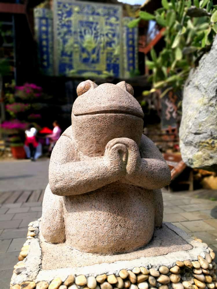 This is a close look at a stone frog statue at a Chinese park.